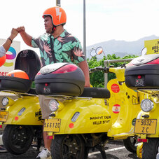 2 personnes se font un check du poing devant une panoplie de hello scoot'