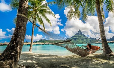 Bora Bora femme dans un hamac qui regarde le lagon de Bora Bora