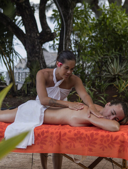 Massage Polynésienne qui masse une touriste sur la plage